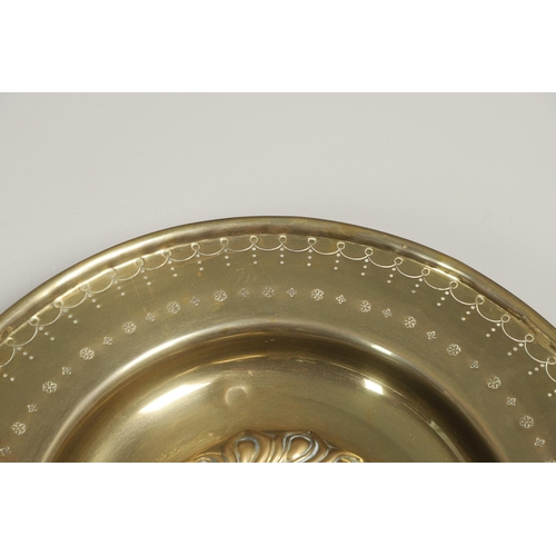 1467 - A LARGE 19TH CENTURY BRASS ALMS DISH. the centre with raised boss and repousse work, the surround wi... 