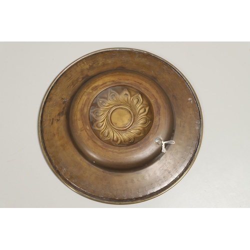 1467 - A LARGE 19TH CENTURY BRASS ALMS DISH. the centre with raised boss and repousse work, the surround wi... 