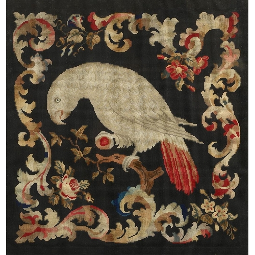 1487 - A 19TH CENTURY NEEDLEWORK STUDY OF A PARROT. depicted perched on a branch surrounded by scrolling an... 