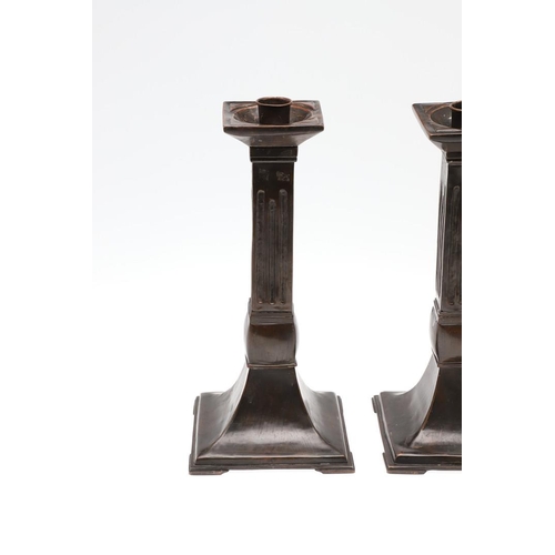 1495 - A PAIR OF ARCHITECTURAL COPPER CANDLESTICKS. the square sconces to fluted columns and flared bases, ... 