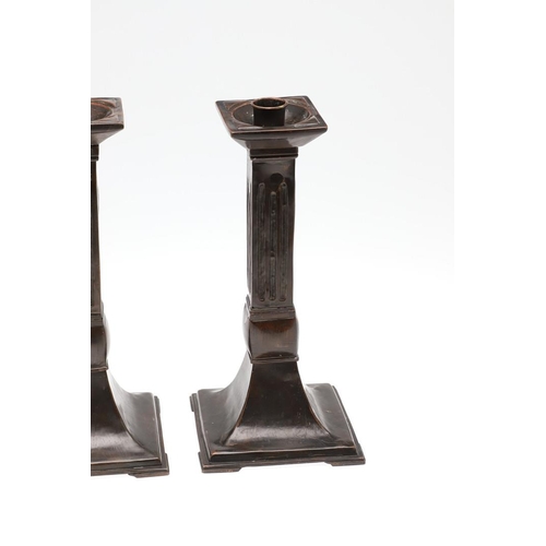 1495 - A PAIR OF ARCHITECTURAL COPPER CANDLESTICKS. the square sconces to fluted columns and flared bases, ... 