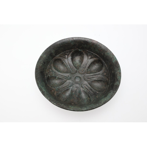 1500 - A GREEK BRONZE PHIALE. with a broad rim and seven almond shaped impressions arranged around a centra... 