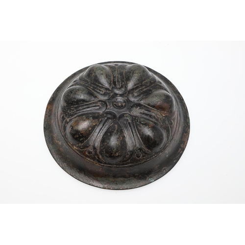 1500 - A GREEK BRONZE PHIALE. with a broad rim and seven almond shaped impressions arranged around a centra... 