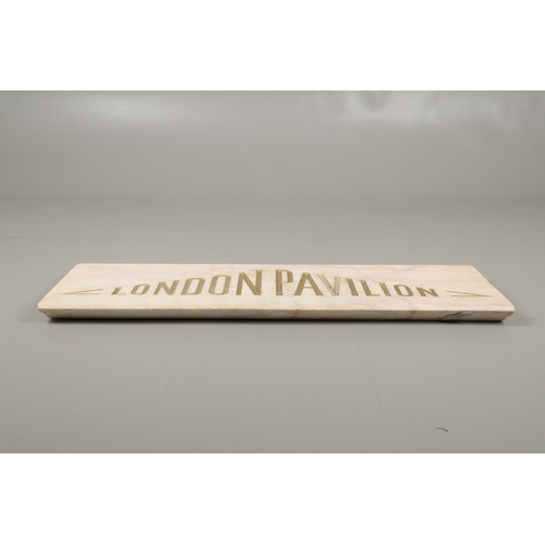 1503 - A PALE PINK MARBLE 'LONDON PAVILION' PLAQUE. the carved lettering in gilt, height 38cm, length 130cm... 