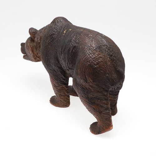 1509 - A BLACK FOREST CARVED BEAR. carved in a walking stance, with painted open mouth and glass eyes, heig... 