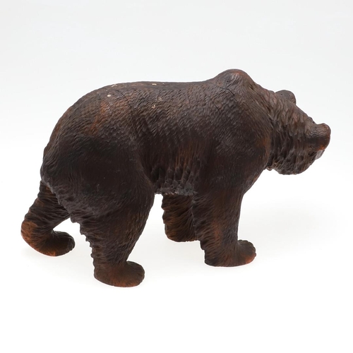 1509 - A BLACK FOREST CARVED BEAR. carved in a walking stance, with painted open mouth and glass eyes, heig... 