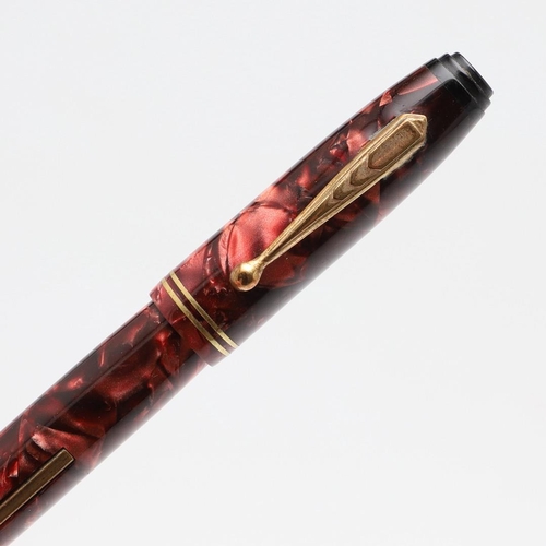 1517 - A PARKETTE LEVERFILL FOUNTAIN PEN. in pink marbled resin with two narrow bands to cap, the nib marke... 