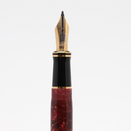 1524 - A PARKER DUOFOLD CENTENNIAL FOUNTAIN PEN. with marbled red resin barrel and cap, the nib marked 18k ... 