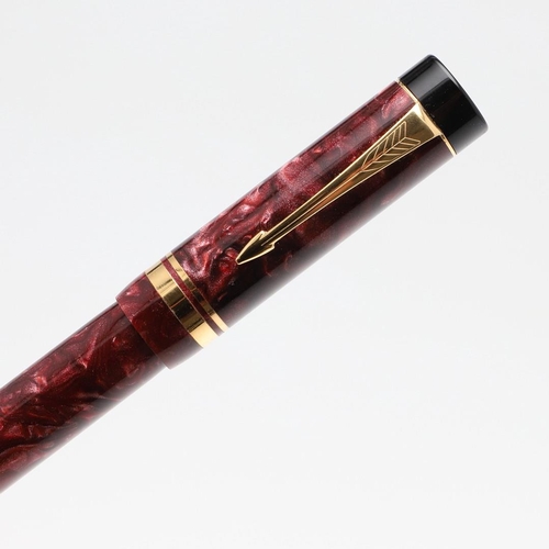 1524 - A PARKER DUOFOLD CENTENNIAL FOUNTAIN PEN. with marbled red resin barrel and cap, the nib marked 18k ... 