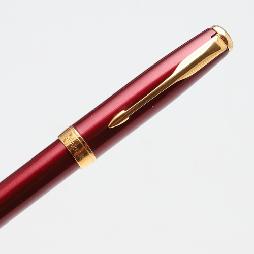 1547 - A MODERN PARKER SONNET FOUNTAIN PEN. with red barrel and cap, gold plated mounts and arrow clip, the... 