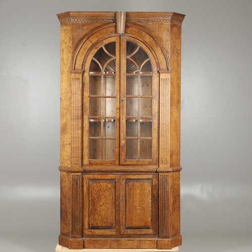 1556 - AN OAK BARREL BACK ALCOVE CUPBOARD. the upper half with Classical architectural features to three sh... 