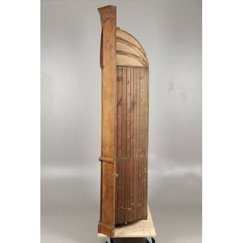 1556 - AN OAK BARREL BACK ALCOVE CUPBOARD. the upper half with Classical architectural features to three sh... 