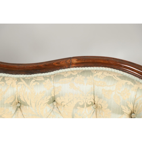 1568 - A ROSEWOOD SHOW FRAME BUTTON BACK TWO SEATER SOFA. 19th century, the wavy frame on carved scroll arm... 