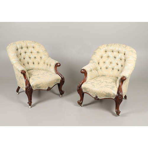 1569 - A PAIR OF MAHOGANY SHOW FRAME BUTTON BACK ARMCHAIRS. 19th century, the scroll and flower carved fram... 