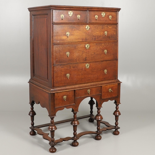 1605 - AN EARLY 18TH CENTURY OAK CHEST ON STAND. the moulded cornice over panelled sides, two short and thr... 