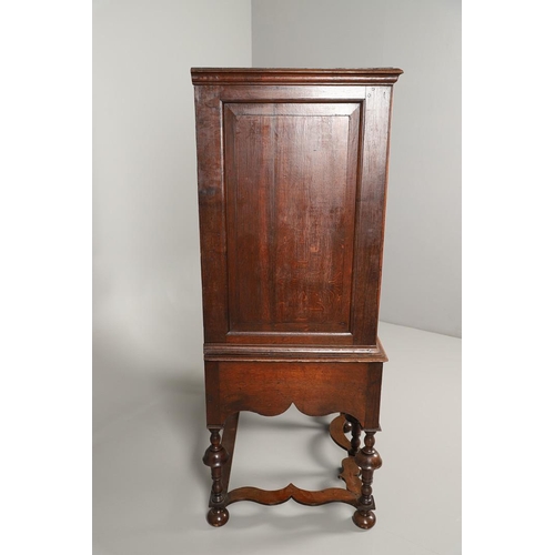 1605 - AN EARLY 18TH CENTURY OAK CHEST ON STAND. the moulded cornice over panelled sides, two short and thr... 