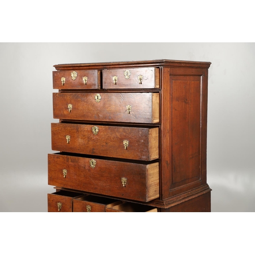 1605 - AN EARLY 18TH CENTURY OAK CHEST ON STAND. the moulded cornice over panelled sides, two short and thr... 