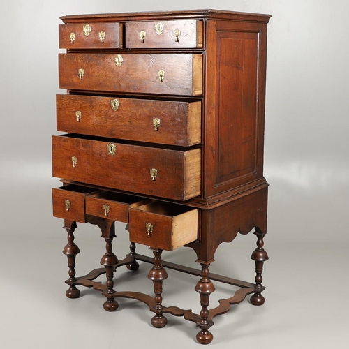 1605 - AN EARLY 18TH CENTURY OAK CHEST ON STAND. the moulded cornice over panelled sides, two short and thr... 