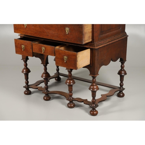 1605 - AN EARLY 18TH CENTURY OAK CHEST ON STAND. the moulded cornice over panelled sides, two short and thr... 