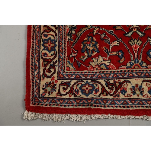 1732 - A NARROW SAROUKH RUNNER, WEST PERSIA, CIRCA 1970. the raspberry field of scrolling vines and palmett... 