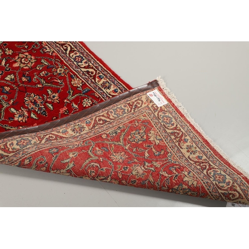 1732 - A NARROW SAROUKH RUNNER, WEST PERSIA, CIRCA 1970. the raspberry field of scrolling vines and palmett... 