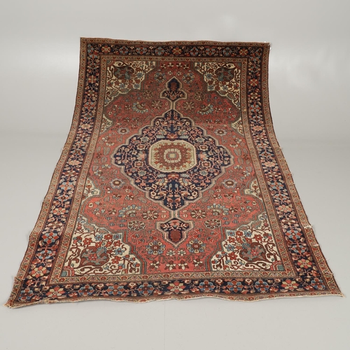 1735 - A SAROUK RUG, WEST PERSIA, CIRCA 1930. the brick red field of angular vines around an ivory and indi... 