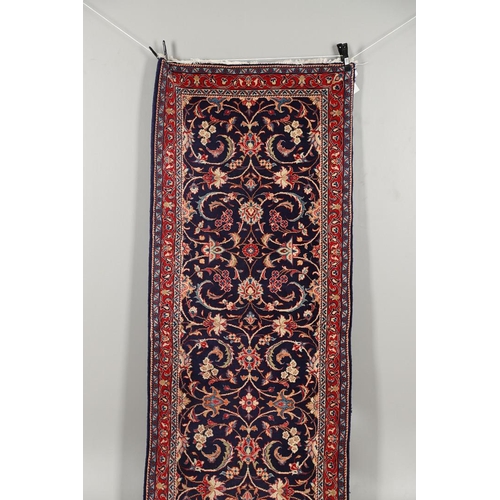 1743 - A NARROW PERSIAN RUNNER, PROBABLY SAROUKH, CIRCA 1970. the indigo field of scrolling vines and palme... 