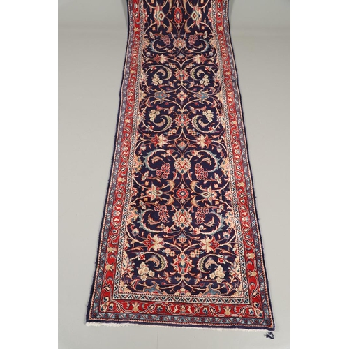 1743 - A NARROW PERSIAN RUNNER, PROBABLY SAROUKH, CIRCA 1970. the indigo field of scrolling vines and palme... 