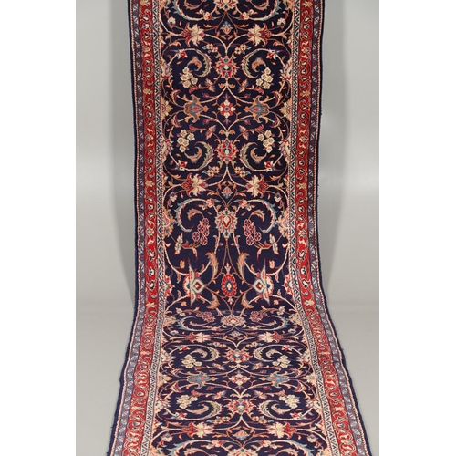 1743 - A NARROW PERSIAN RUNNER, PROBABLY SAROUKH, CIRCA 1970. the indigo field of scrolling vines and palme... 