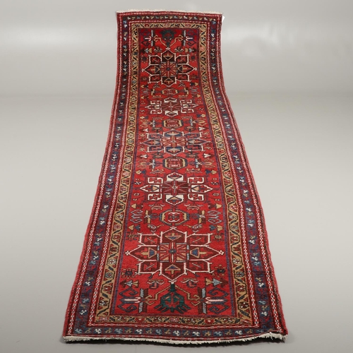 1746 - A HERIZ RUNNER, NORTH WEST PERSIA, 2ND HALF 20TH CENTURY. the brick red field with a column of styli... 