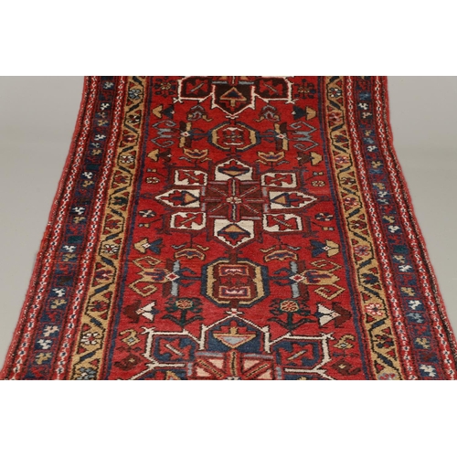 1746 - A HERIZ RUNNER, NORTH WEST PERSIA, 2ND HALF 20TH CENTURY. the brick red field with a column of styli... 