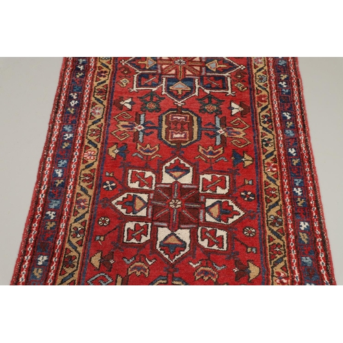 1746 - A HERIZ RUNNER, NORTH WEST PERSIA, 2ND HALF 20TH CENTURY. the brick red field with a column of styli... 