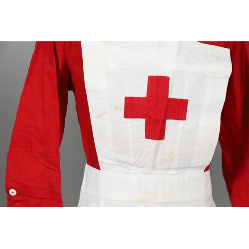 677 - VINTAGE NURSES UNIFORMS & RED CROSS APRONS. A qty of Nurses Uniforms to include a blue Chambray cott... 