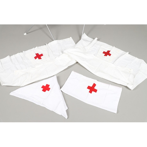 677 - VINTAGE NURSES UNIFORMS & RED CROSS APRONS. A qty of Nurses Uniforms to include a blue Chambray cott... 