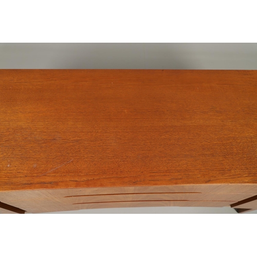 773 - MID CENTURY TEAK SIDEBOARD - BEAUTILITY. A large teak sideboard with a curved front, with three cent... 