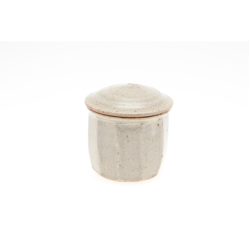 817 - RICHARD BATTERHAM (1936-2021) - LIDDED JAR. (d) A stoneware cut sided jar with celadon glaze and dom... 