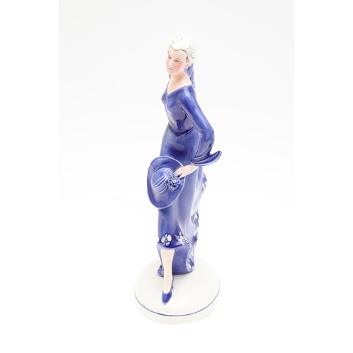 822 - KATZHUTTE GERMAN ART DECO FIGURE OF A LADY. A 1930's porcelain figure of a lady in a blue dress, hol... 