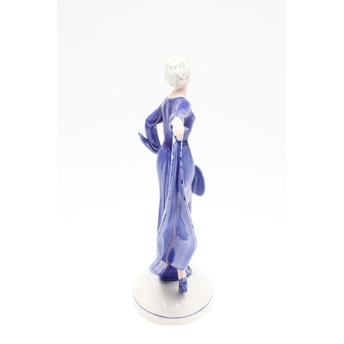 822 - KATZHUTTE GERMAN ART DECO FIGURE OF A LADY. A 1930's porcelain figure of a lady in a blue dress, hol... 