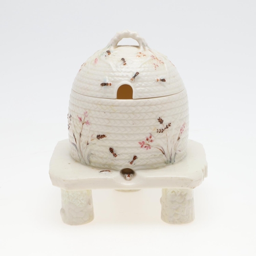 852 - BELLEEK FIRST PERIOD HONEY POT. A lidded honey pot in the form of a wicker bee skep, painted with be... 