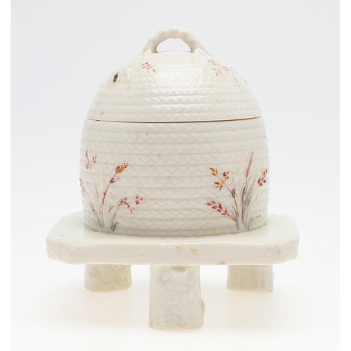 852 - BELLEEK FIRST PERIOD HONEY POT. A lidded honey pot in the form of a wicker bee skep, painted with be... 