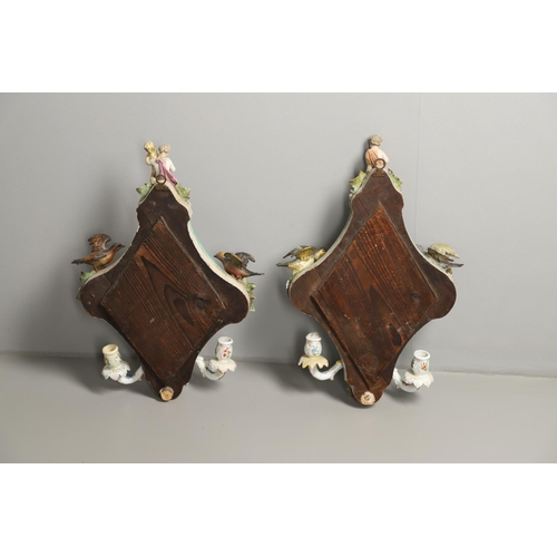 865 - PAIR OF CONTINENTAL PORCELAIN MIRRORS. Probably German, the shaped mirrors each mounted with cherub ... 