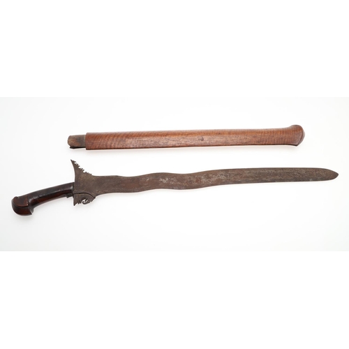 112 - TWO MALAYAN KRIS TYPE SHORT SWORDS AND SCABBARDS. With a 36c, wavy edged blade and elaborately carve... 