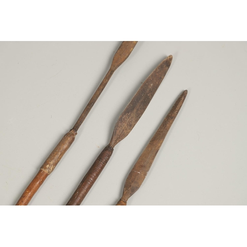 201 - THREE AFRICAN THROWING SPEARS. An African spear with a leaf shaped point on square shaft and wooden ... 