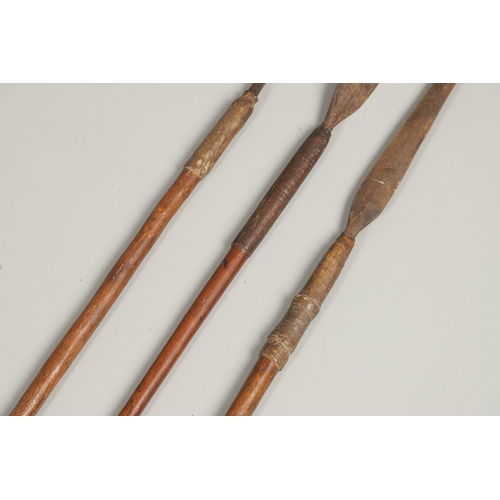 201 - THREE AFRICAN THROWING SPEARS. An African spear with a leaf shaped point on square shaft and wooden ... 