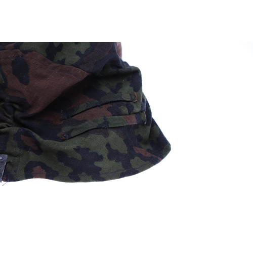 231 - A SECOND WORLD WAR GERMAN WAFFEN-SS STEEL HELMET CAMOUFLAGE COVER. A Waffen-SS steel helmet reversib... 