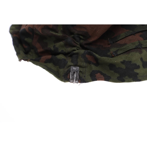 231 - A SECOND WORLD WAR GERMAN WAFFEN-SS STEEL HELMET CAMOUFLAGE COVER. A Waffen-SS steel helmet reversib... 