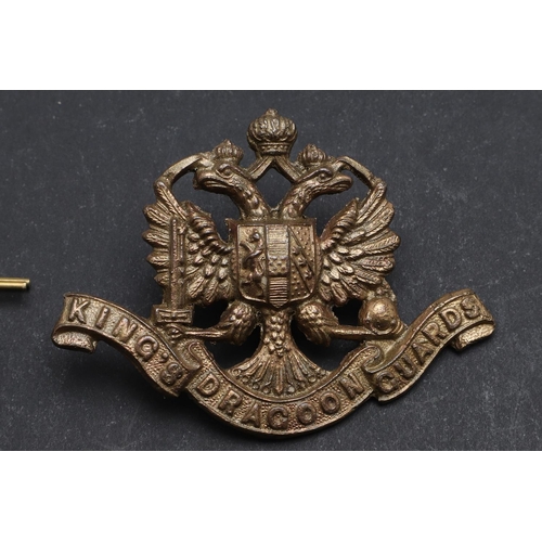 244 - AN INTERESTING COLLECTION OF THREE 1ST KING's  DRAGOON GUARDS CAP BADGES. Three 1st King's  Dragoon ... 