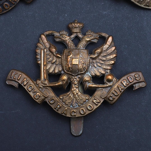 244 - AN INTERESTING COLLECTION OF THREE 1ST KING's  DRAGOON GUARDS CAP BADGES. Three 1st King's  Dragoon ... 