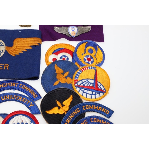 265 - A COLLECTION OF AMERICAN HAT INSIGNIA AND OTHER BADGES AND PATCHES. A mounted collection of crossed ... 