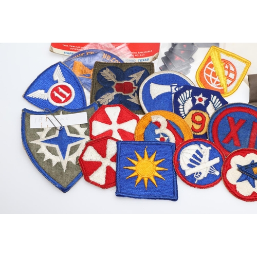 265 - A COLLECTION OF AMERICAN HAT INSIGNIA AND OTHER BADGES AND PATCHES. A mounted collection of crossed ... 